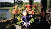 Handgjord docka bland växterna i blomlådan.