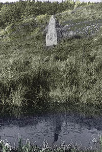 Runsten från 1000-talet i Kuddby socken vid vägen till Å. Stenen speglar sig källan. Med sin placering markerar den både vägen och vattnet, väsentliga för valet av bosättningsplats.