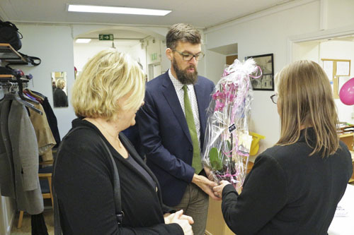 Riksarkivets representant överräcker en blomsterkvast